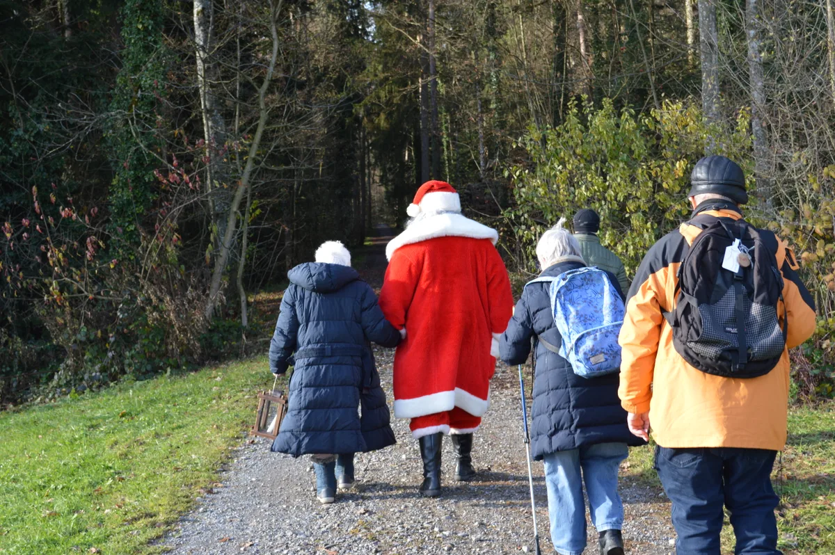 Eine Gruppe spaziert mit dem Samichlaus in den Wald.